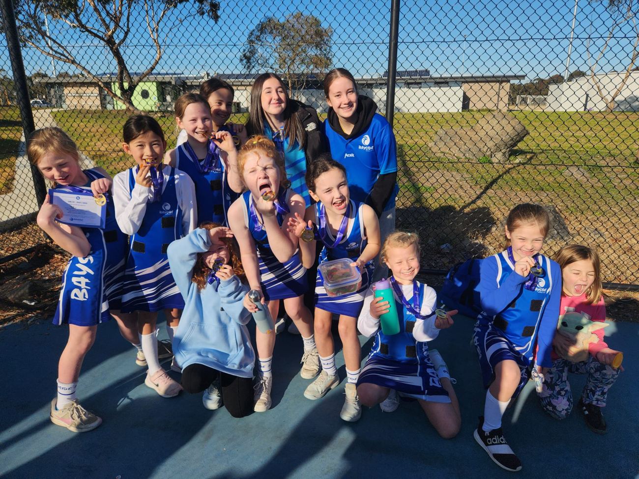 A young Bayside team celebrating with their coaches