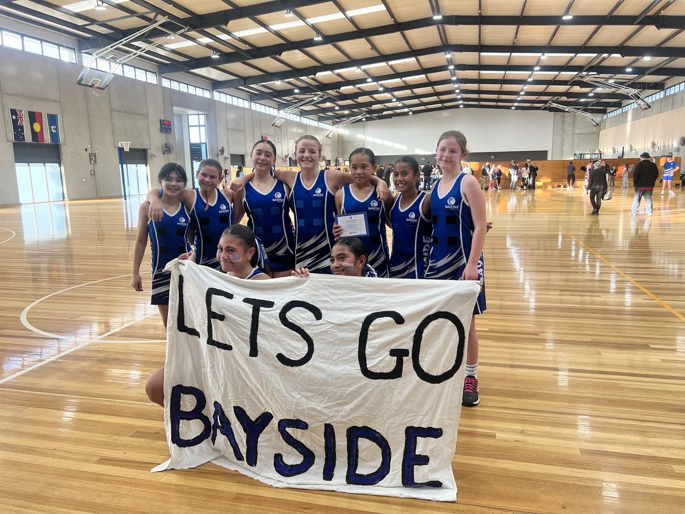 A Bayside team holding a Lets Go Bayside banner